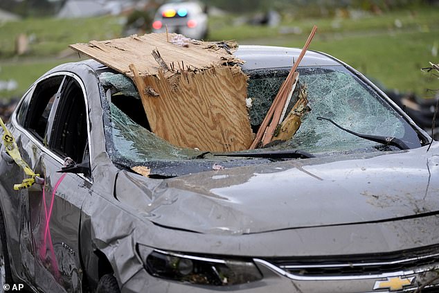 A car is damaged by flying debris during the Greenfield tornadoes