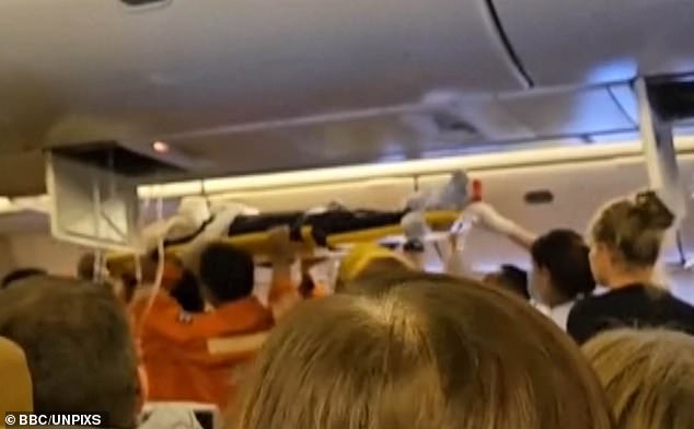 Video shows emergency services removing a passenger from the cabin on a stretcher