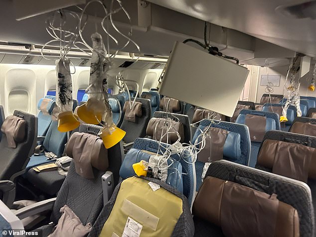 Oxygen masks hang from the ceiling in the cabin of a Singapore Airlines flight