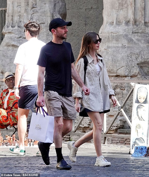 She paired a white cardigan underneath and opted for loose-fitting black shorts as she and her husband did some sightseeing around the city.