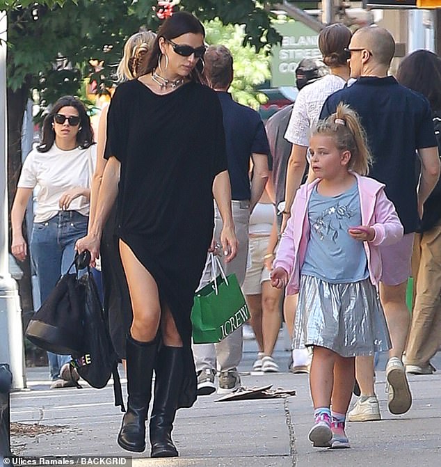 The beauty was dressed in a black T-shirt dress with short sleeves, an asymmetrical hem and also rolled up on the right side to create a small slit