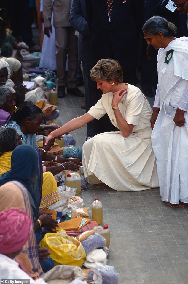 She has the touch: Diana leans in to shake hands with an 'Untouchable', India's lowest caste, in Hyderabad, India, in 1992