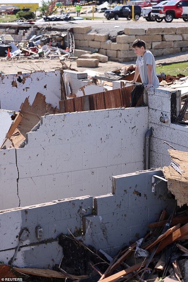 Landyn Ergish, 12, of Greenfield, Iowa, looks into the basement bathroom where he hid with his three siblings and mother when a tornado destroyed their home