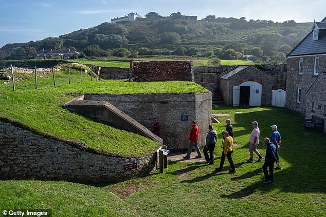 People visit a German bunker on Alderney Island, Guernsey, where thousands of workers died during the Second World War
