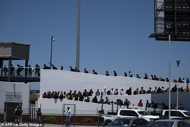 Asylum seekers walk for their appointment for an asylum interview with US authorities at the El Chaparral border crossing in Tijuana, Mexico