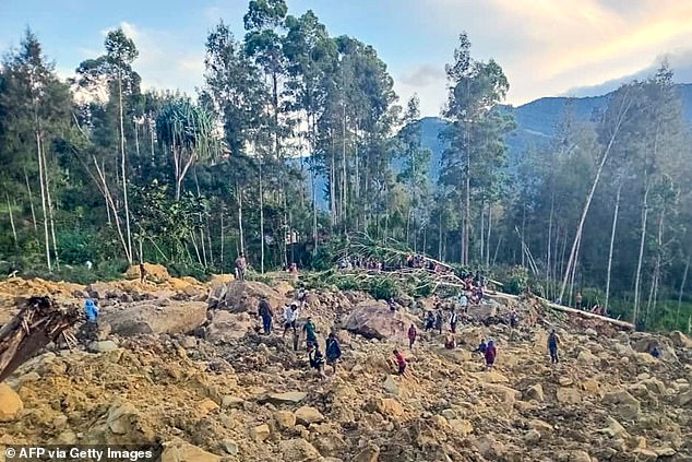 People gather at the site of a landslide in Maip Mulitaka in Papua New Guinea's Enga Province on May 24, 2024