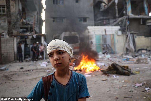 An injured Palestinian boy stands next to the rubble of a family home that was hit during an Israeli bombardment in the Tal al-Sultan neighborhood of Rafah in southern Gaza on Monday.