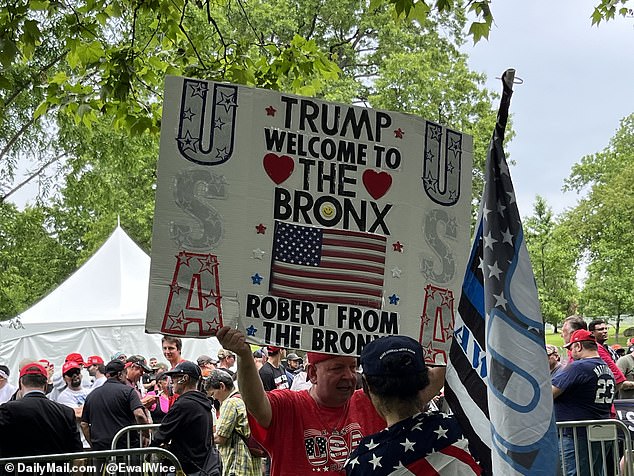 A man holds a sign welcoming Trump to the Bronx from 'Robert from the Bronx' ahead of the ex-president's rally