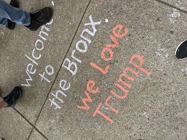 “We Love Trump” is written in chalk on the sidewalk in Crotona Park as supporters gather