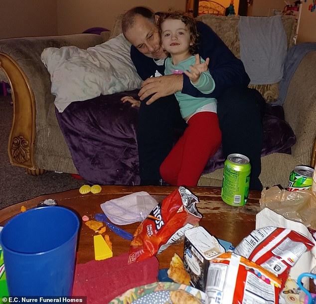 The little girl can be seen being cuddled by her father — who was also convicted in her death — in front of a coffee table full of Mountain Dew and junk food.