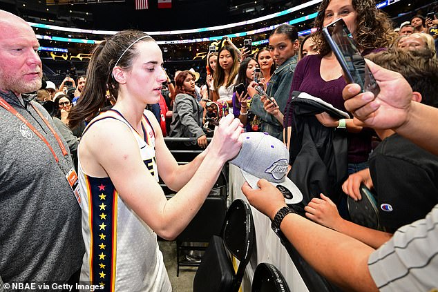 Caitlin Clark signs autographs after Friday's game against the Los Angeles Sparks in LA