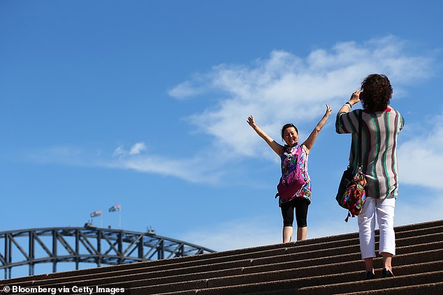 Chinese tourists are pictured taking photos in front of the Sydney Harbor Bridge