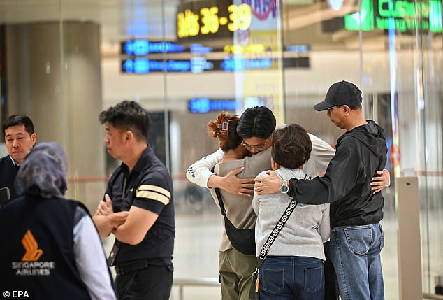 Passengers of Singapore Airlines Flight SQ321, which made an emergency landing in Bangkok, greet relatives upon arrival at Changi Airport in Singapore