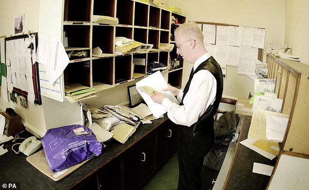 A photo from the year 2000 showing an employee sorting letters in the mailroom