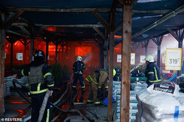 Firefighters work at the site of a home goods shopping center hit by a Russian airstrike