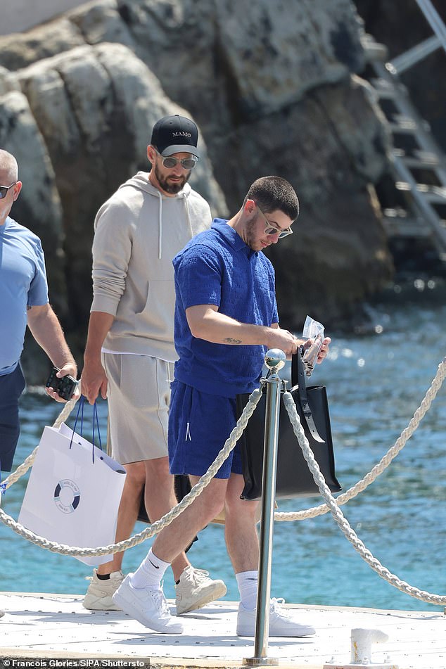 The sibling duo appeared in good spirits as they brought their treats to the boat, and Nick was captured with a pack of cigars in his hand.