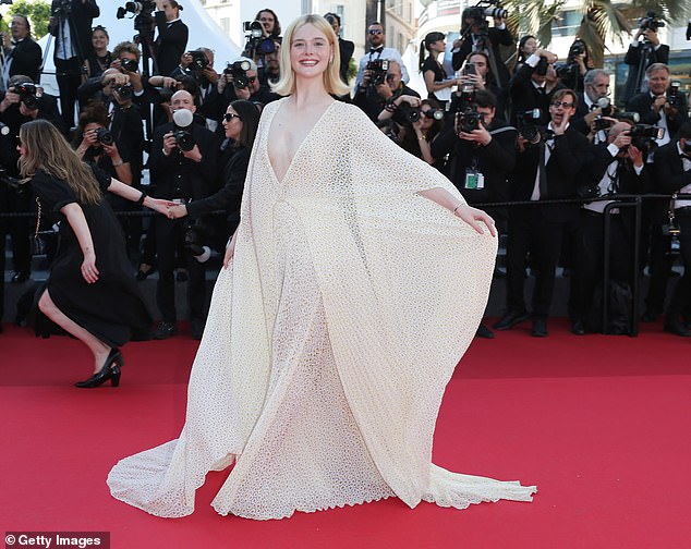 The American actress looked stunning in a dramatic cream-colored hooded dress as she posed for photos on the red carpet