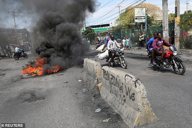 Motorists pass a burning barricade during a protest following an escalation of violence, in Port-au-Prince, Haiti, March 7, 2024