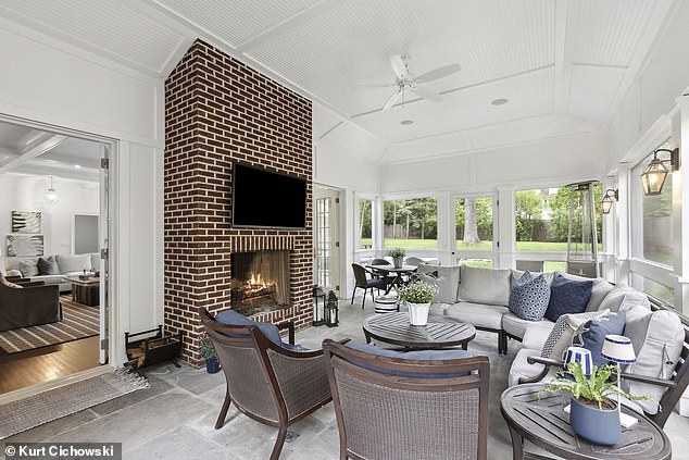 A sun-drenched family room has high ceilings and French doors to an inviting backyard