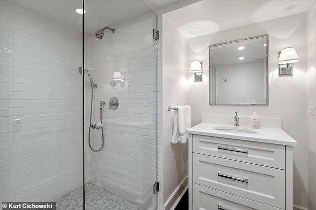 Pictured: A luxuriously tiled bathroom with all white details adds timeless feng shui to the space