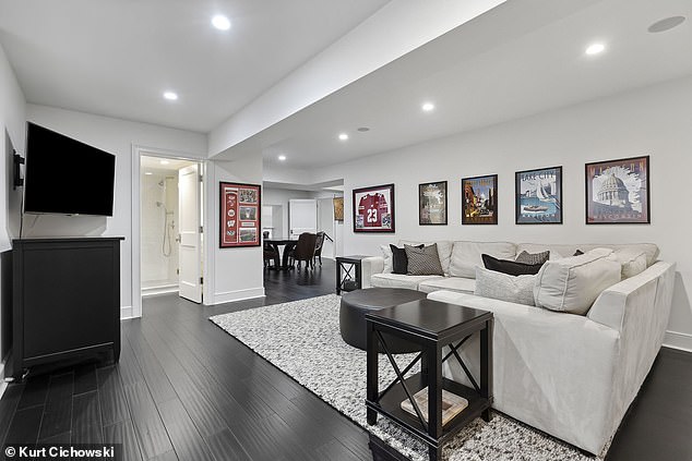 Pictured: The basement living area with modern furniture and sports decor