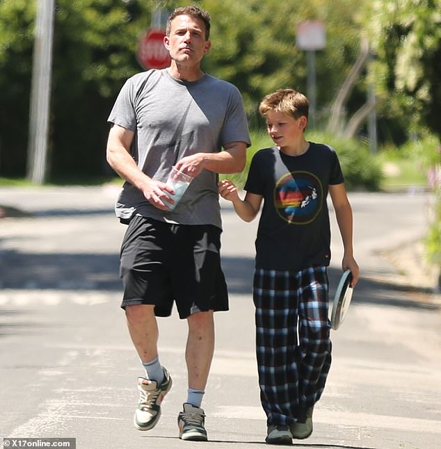 He went for a walk with his 12-year-old son Samuel Garner and served dad style in a gray lightning bolt t-shirt and black gym shorts.
