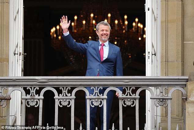 King Frederik looked dapper in a navy blue suit and red tie as he waved to the crowd from the balcony of Amalienborg Palace today