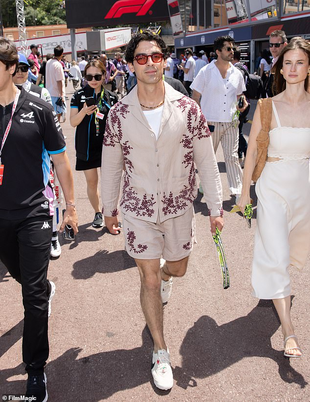 Joe was all smiles as he attended the race, wearing a beige patterned shirt and matching shorts