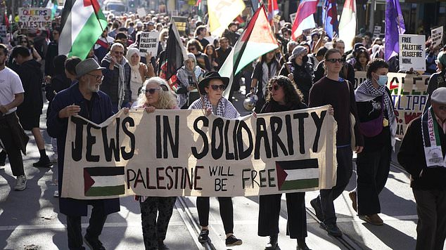 In the photo: demonstrators carry a sign with the text "Jews in solidarity: Palestine will be free'
