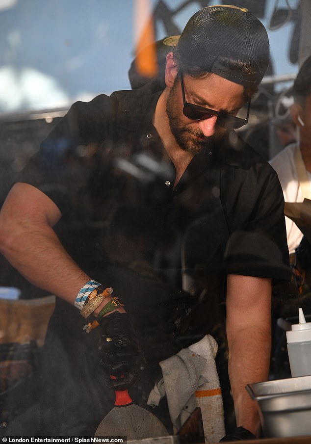 He looked focused and busy at work as he cleared the grill and continued making sandwiches on the grill