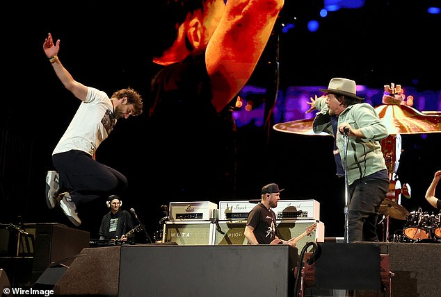 Imitating the image on his T-shirt, Cooper showed off his rocker-inspired high jump as he performed with Vedder and singer-songwriter Neil Young's band Rockin' in the Free World.