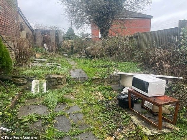 The takeaway was left with a disused microwave and piled-up furniture in the overgrown backyard