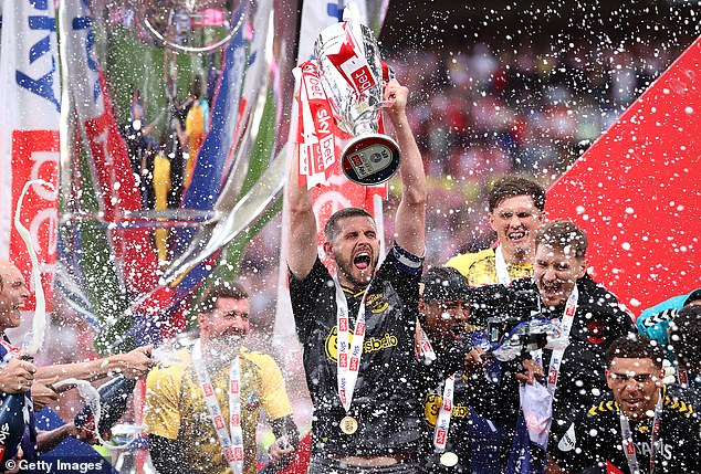 Saints skipper Jack Stephens lifts the play-off title after their win at Wembley