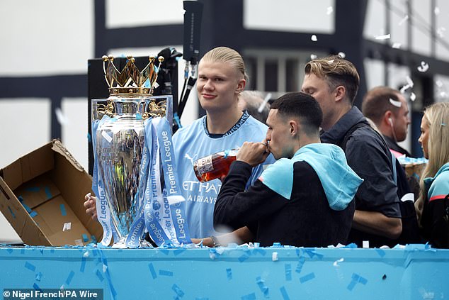 Erling Haaland (left) looked on as Phil Foden enjoyed a drink during the raucous parade