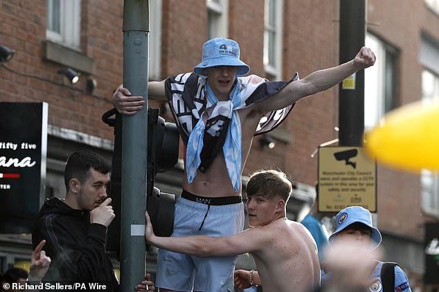 These fans were seen climbing a lamppost to get a good look at the players