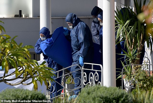 The photo shows police removing a body from the house where the double-murder suicide took place