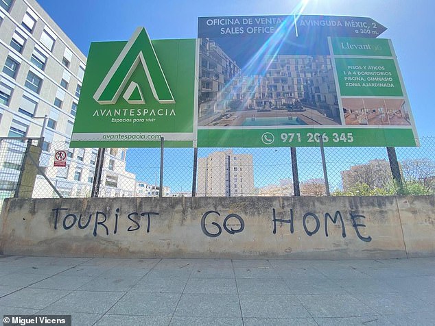 'Tourist Go Home' is scrawled in English on a wall beneath a property promotion billboard in Nou Llevant, Mallorca, a neighborhood that has seen a huge influx of foreign buyers in recent years.  It is one of many examples of anti-tourist graffiti