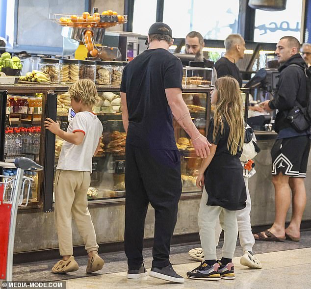 After approaching the busy counter, Chris was spotted chatting with his children while looking at a pastry in the window