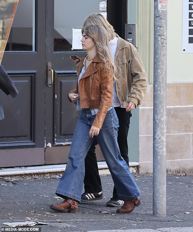 Mia, 18, wore a 70s-inspired outfit as she showed off blue wide-leg jeans, a white top topped with a blue shirt and a brown leather jacket