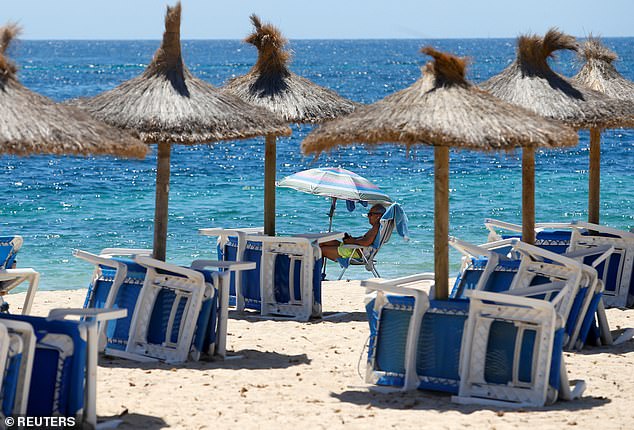 A tourist enjoys the weather on the beach of Magaluf
