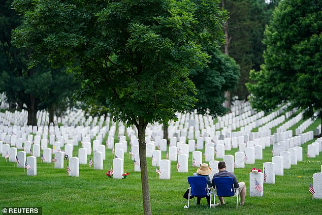 Visitors rest at gravestones at Arlington National Cemetery on Memorial Day in Arlington, Virginia, USA, May 27, 2024