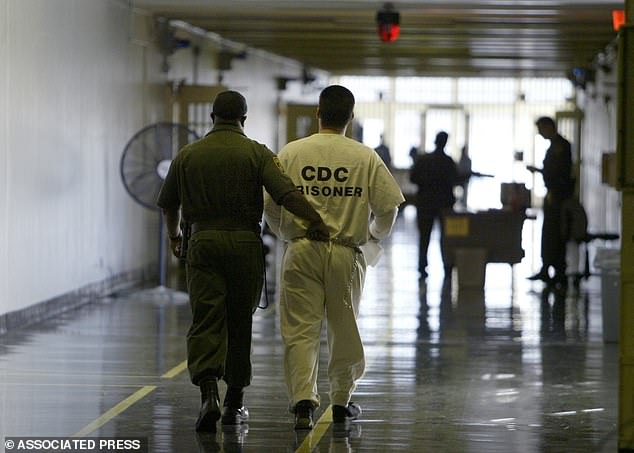A prison guard escorts an inmate down a hallway at the California Medical Facility in Vacaville, California (file photo)