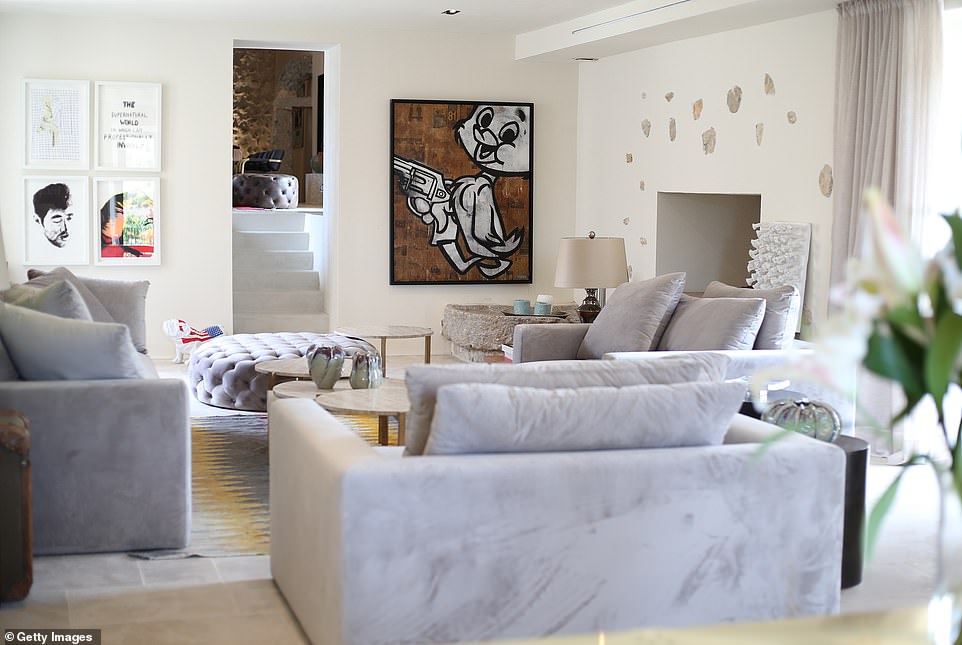 The interior of the villa showcases a large living room with high ceilings and pop culture artwork