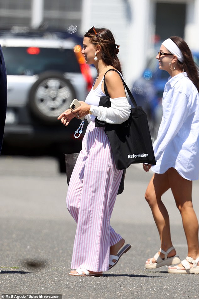 She looked effortlessly chic in pinstripe linen trousers, a white T-shirt and Hermes sandals