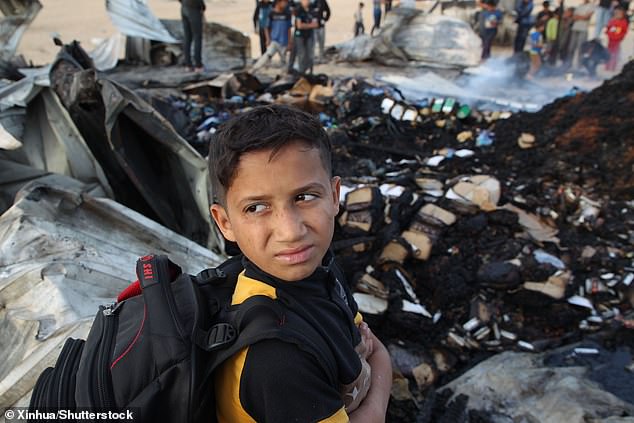 Child looks at the rubble after Israel's bombardment of tents in Rafah