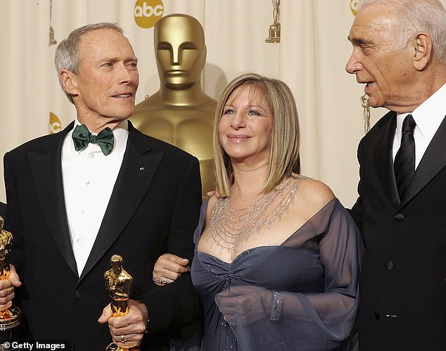 Clint, far left, is held by Barbra Streisand after winning with his producer Al for Million Dollar Baby, far right