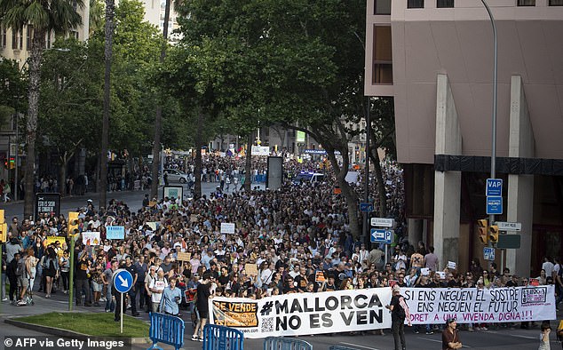 Protesters hold a banner with the text 