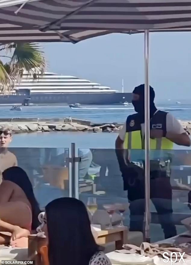 An officer wearing a balaclava stands guard during 'routine checks' at the Marbella resort