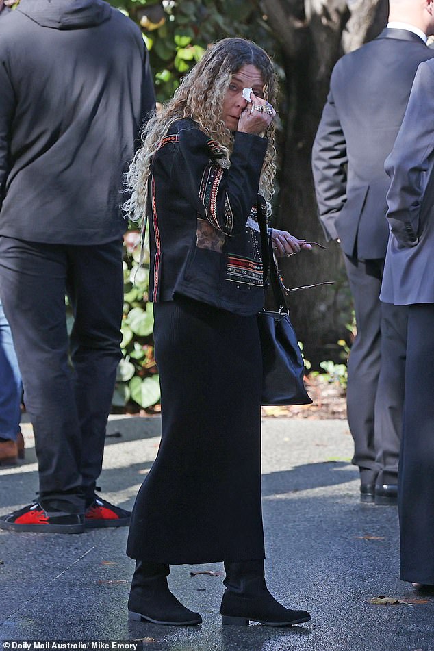 A mourner at the service in McCarthy's hometown of Fremantle wipes away a tear