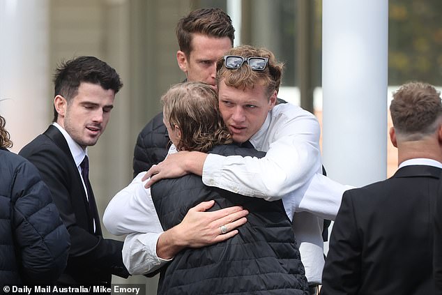 McCarthy's death shook the football world (photo: mourners comfort each other during the service)